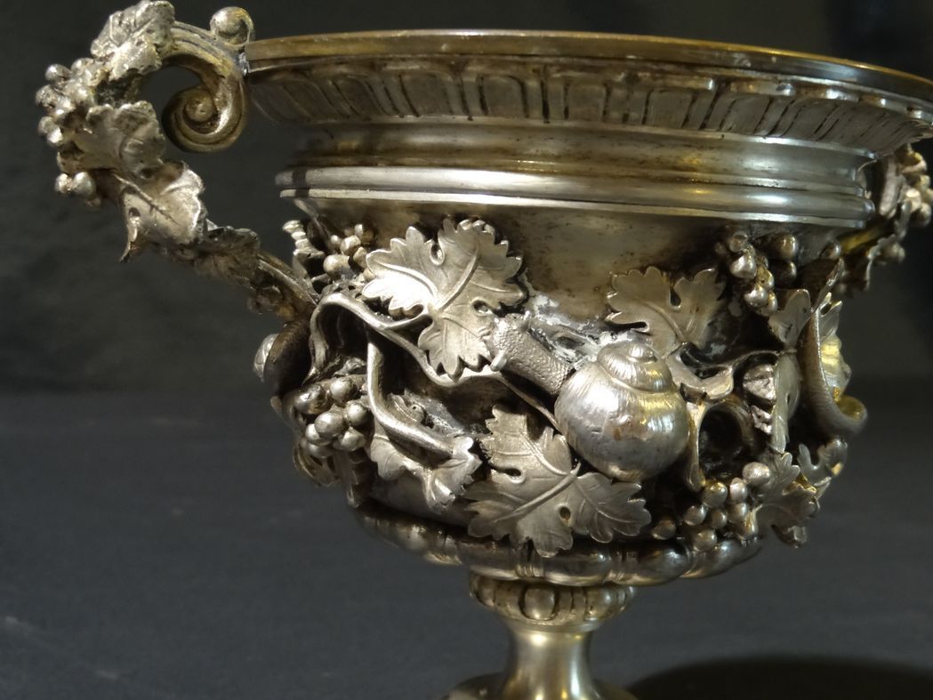 Carved silver bronze vase mounted on marble pedestal