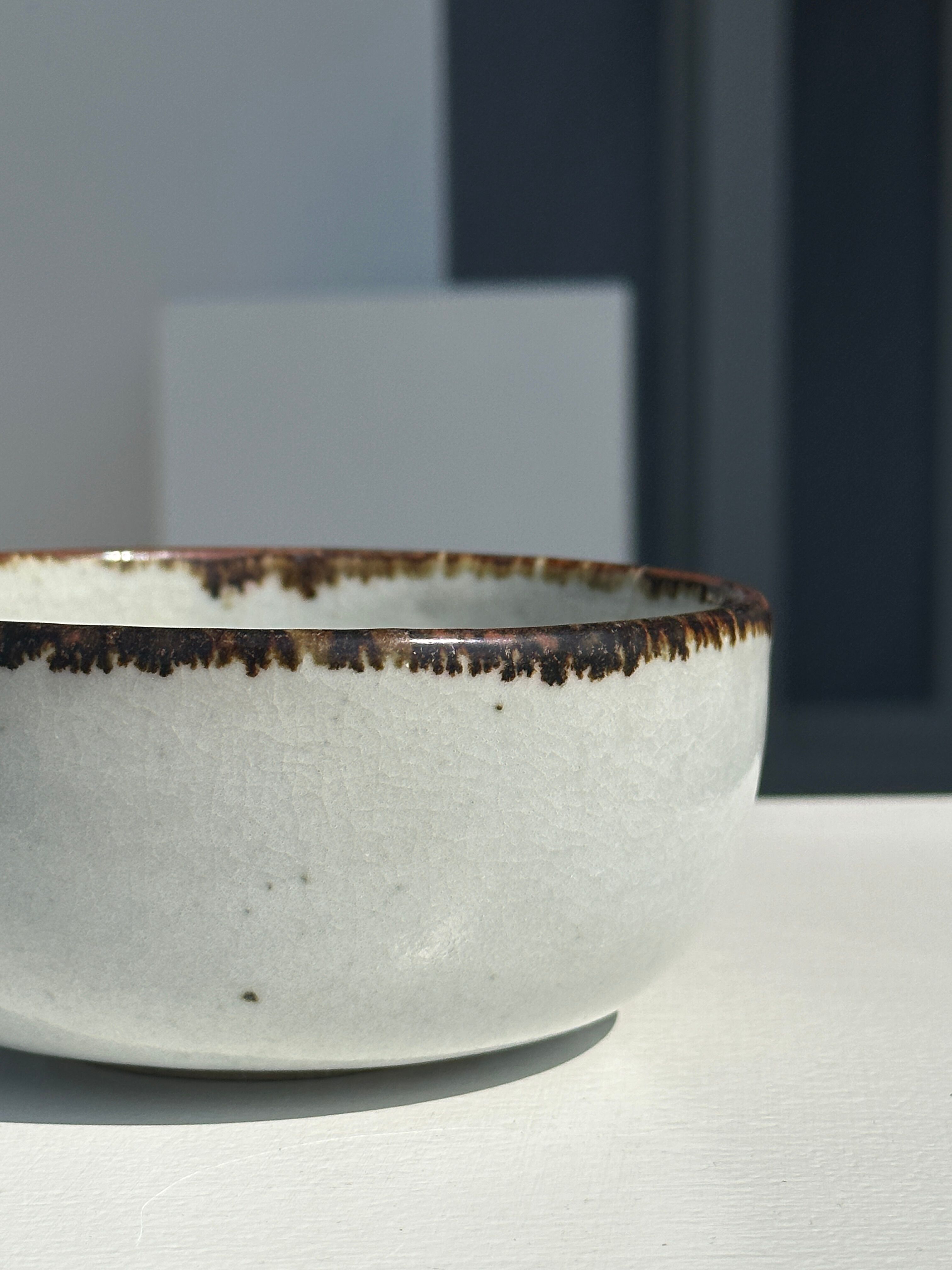 Small white glazed ceramic bowl black edges