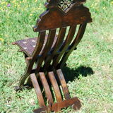 A folding chair and a carved Syrian table with 19th-century mother-of-pearl inlays.