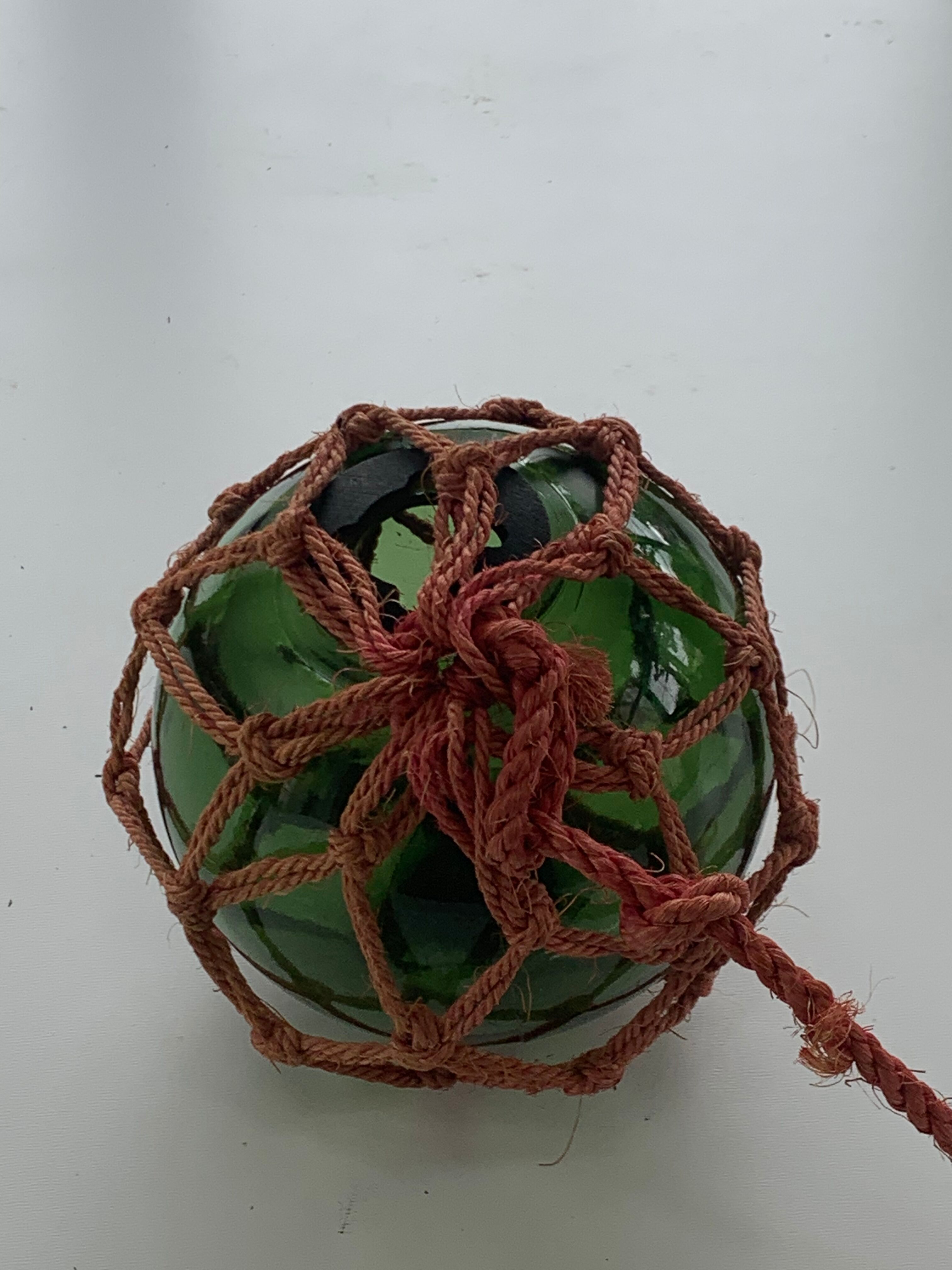 Globe, green glass float and vintage rope