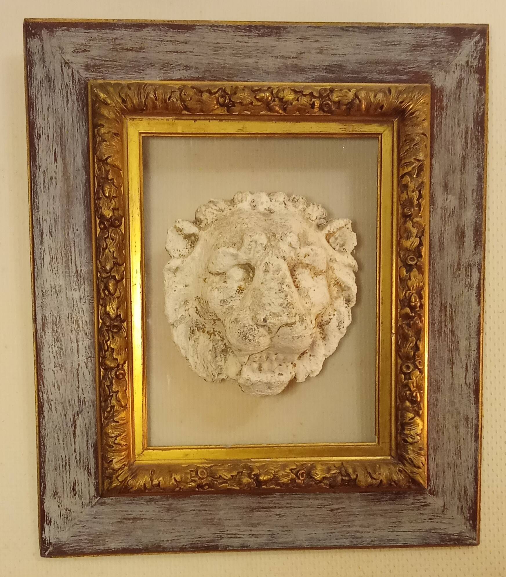 Antique gilded frame with stone lion head ornament on plexiglass