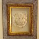 Antique gilded frame with stone lion head ornament on plexiglass