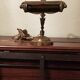 Antique desk piano lamp in chiselled brass.