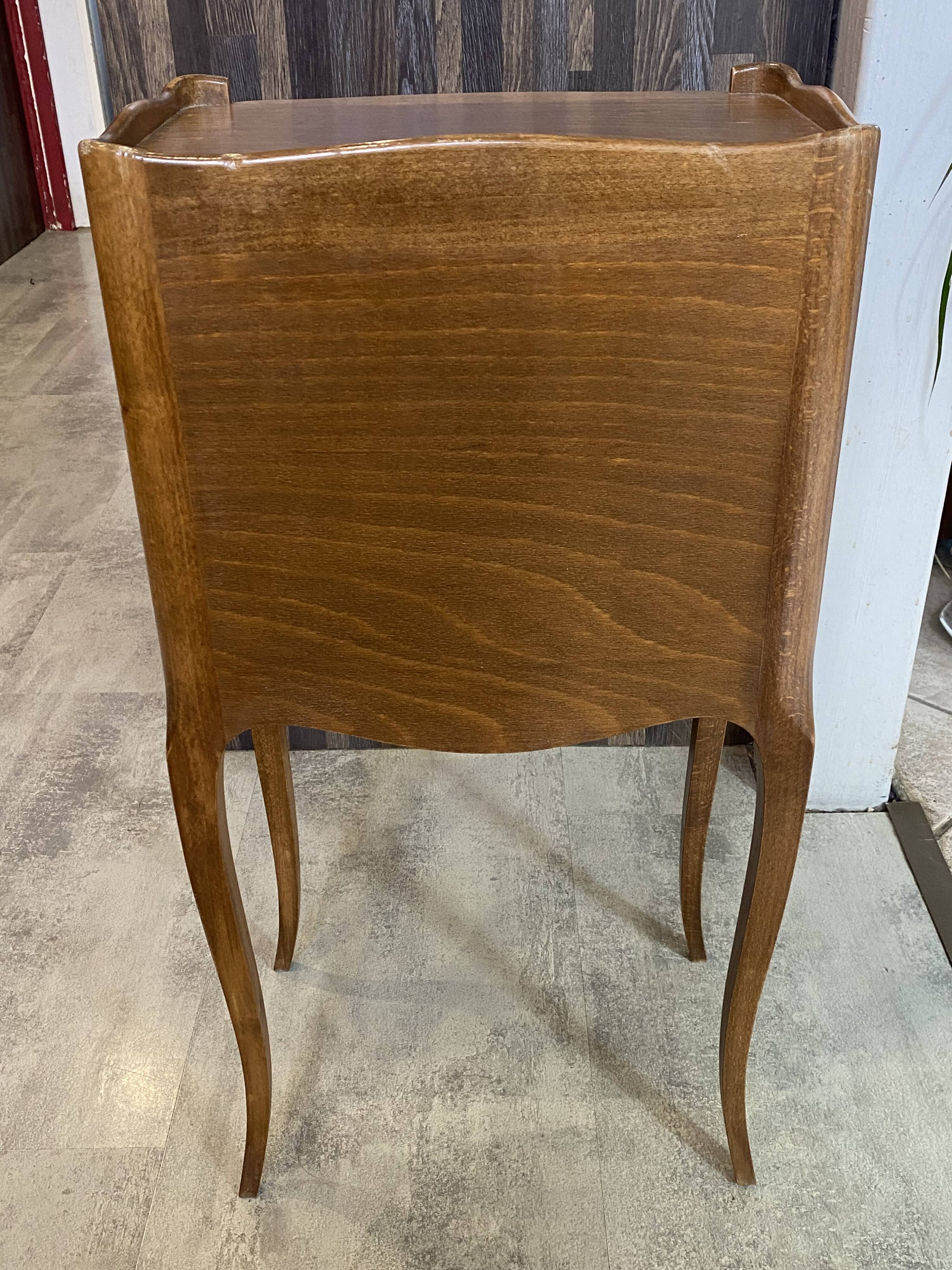 A bedside table with a drawer and a niche in Louis XV style.