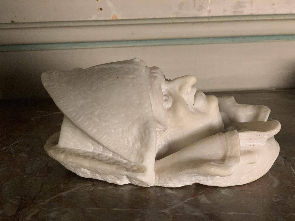 Marble sculpture, man's head in a hat.