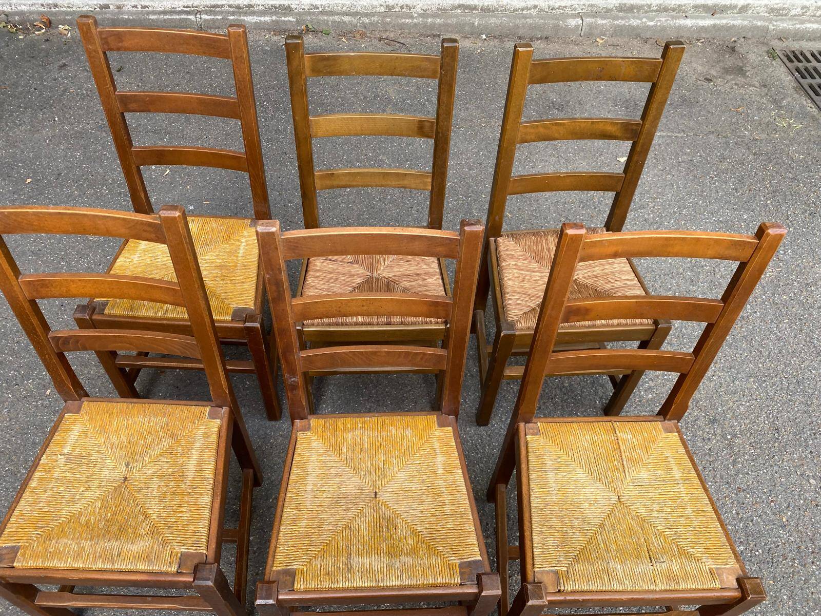 6 light solid wood chairs with high straw backs, farmhouse style.