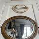 Antique oval mirror in gilded wood, bevelled mercury glass, 19th century.