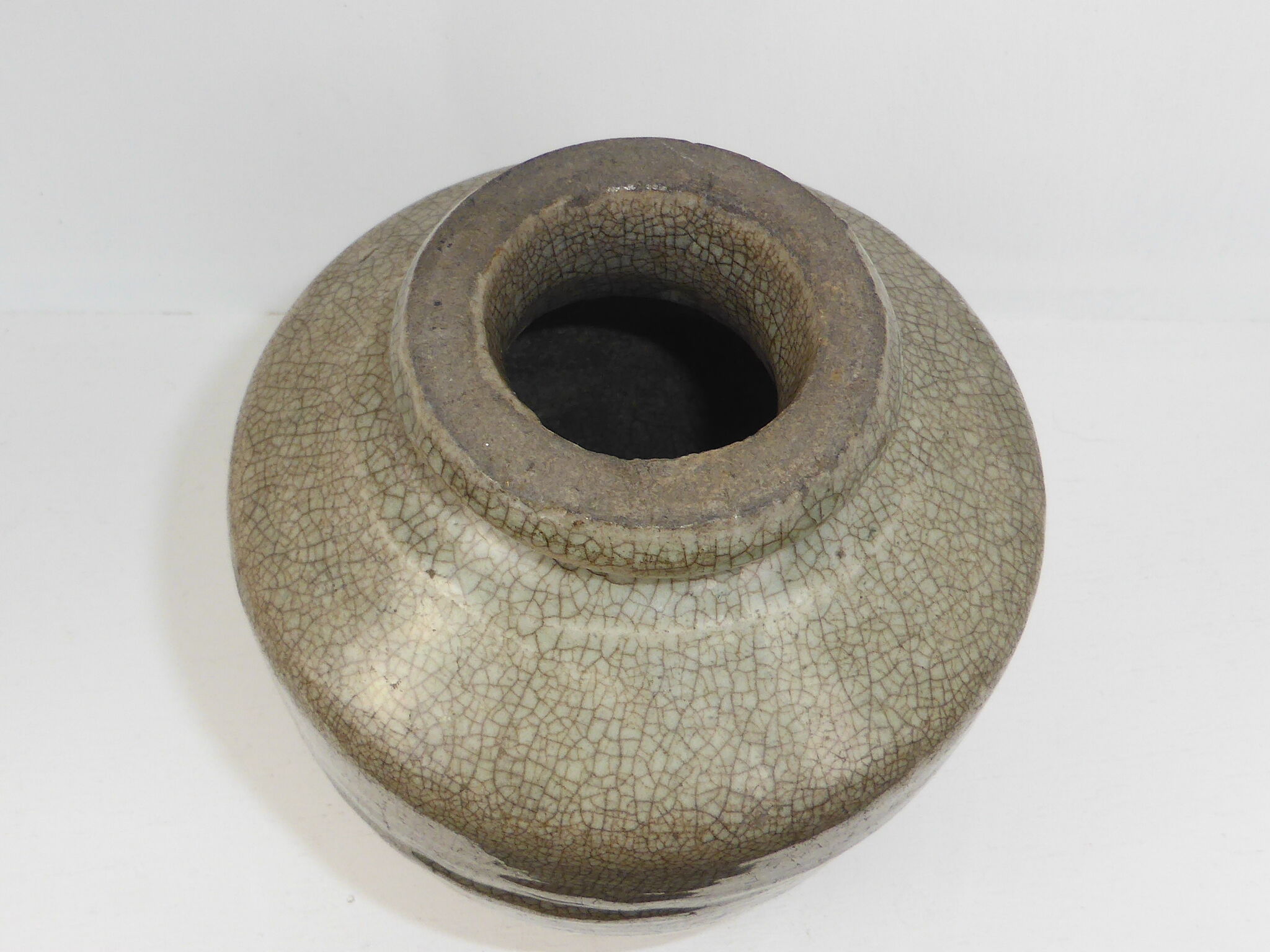 Ancient vase in khaki grey-green cracked sandstone