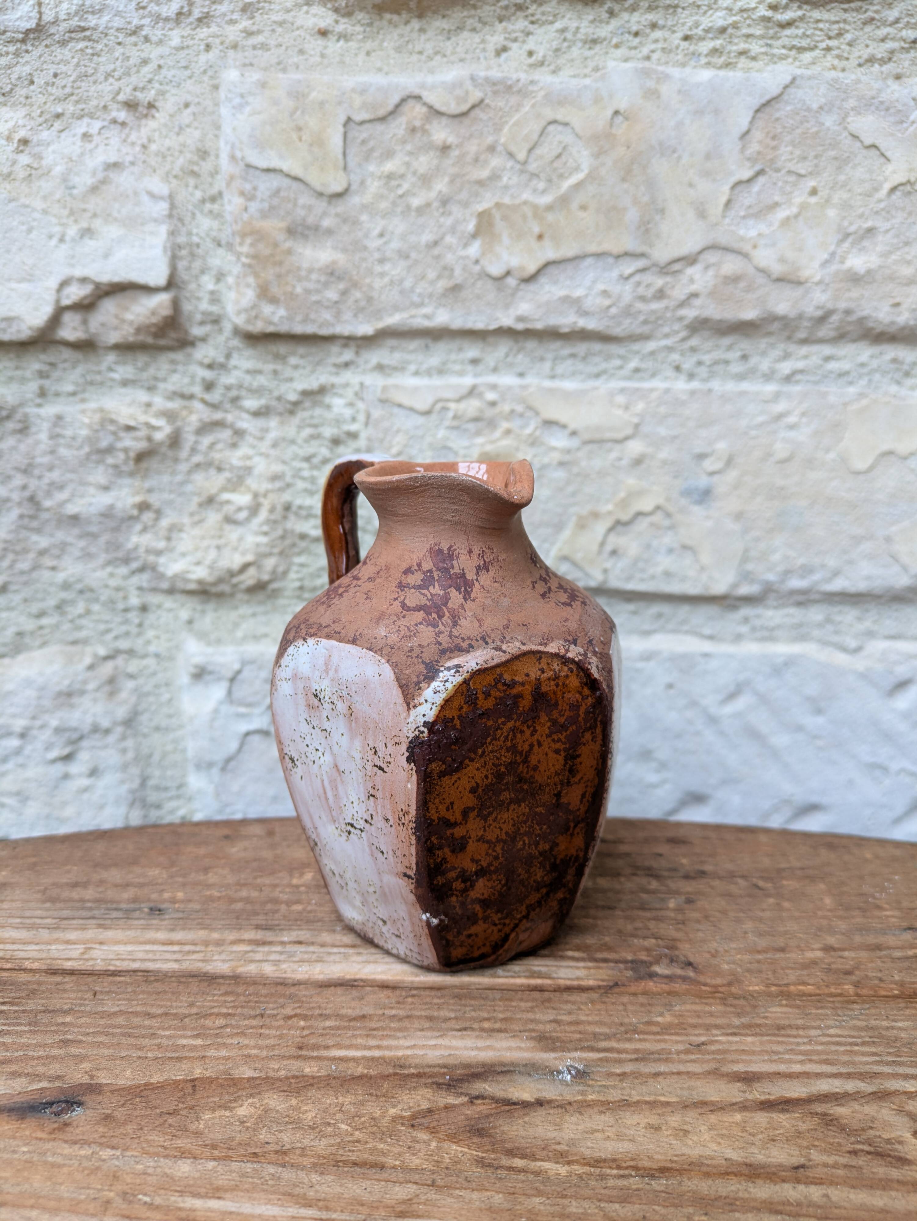 Old small pitcher in glazed terracotta