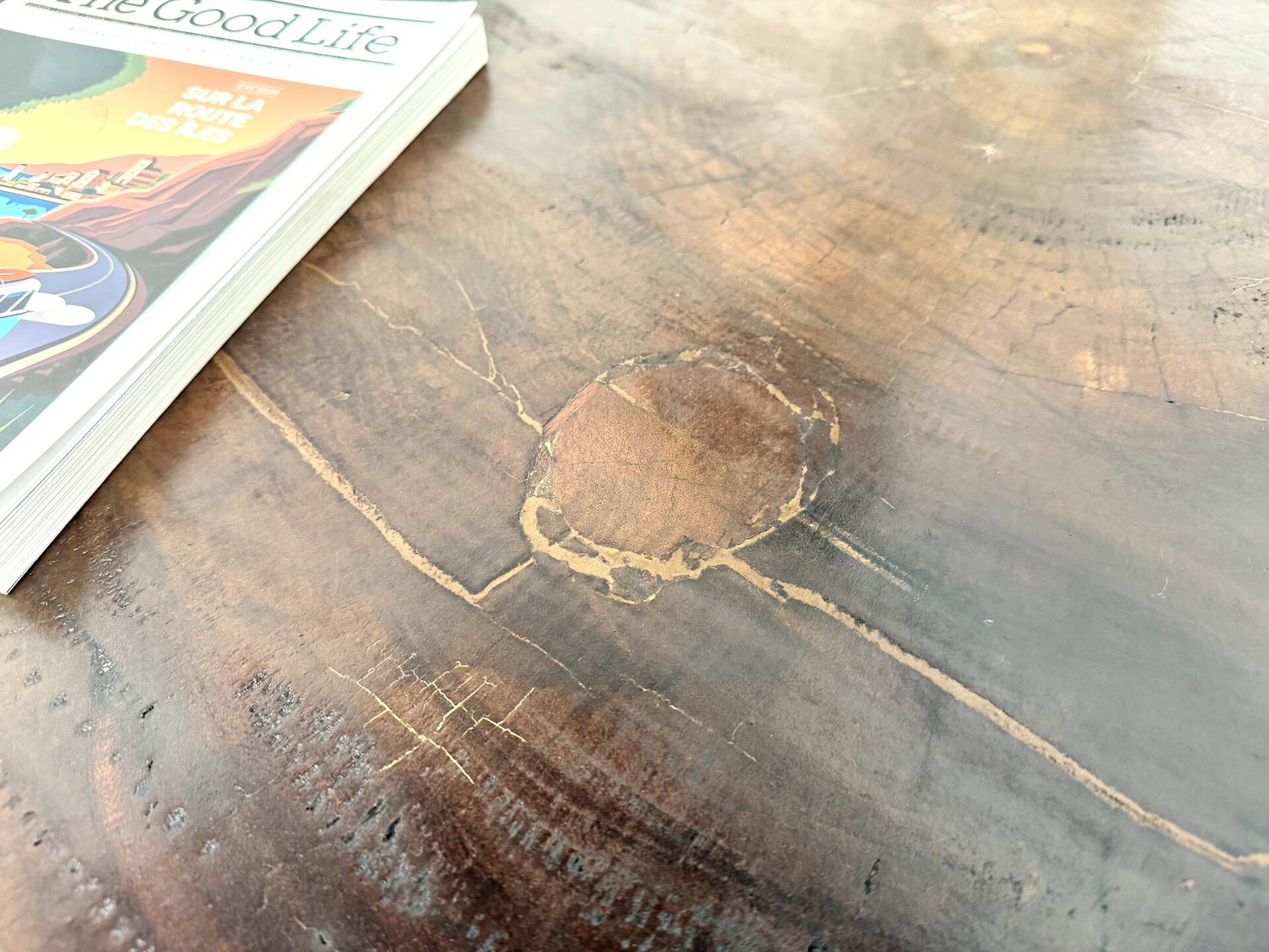 Brutalist coffee table in solid teak, monolithic slab, tripod base.