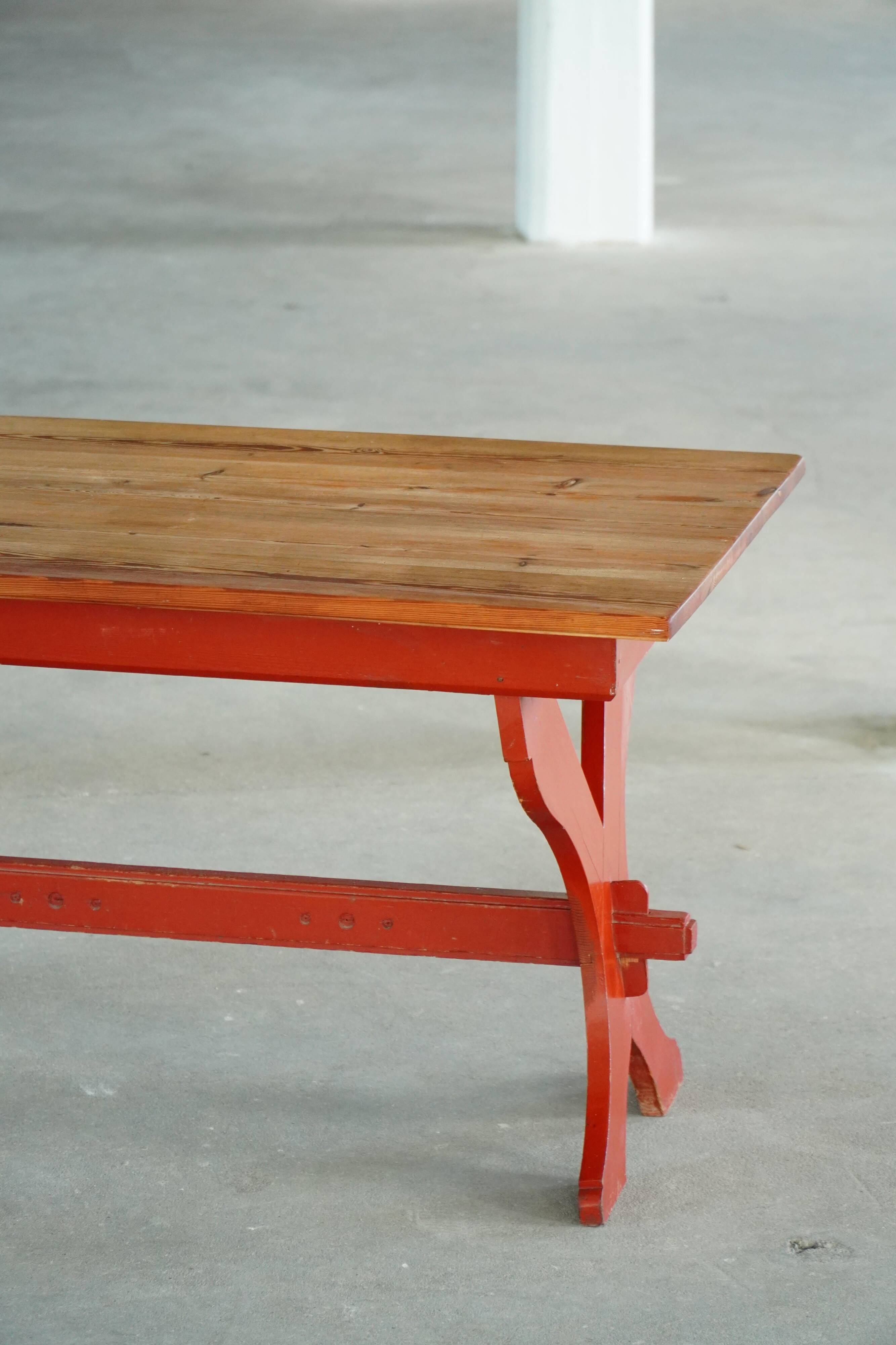 Rustic farmhouse dining table in painted red pine, Sweden, 1920s.