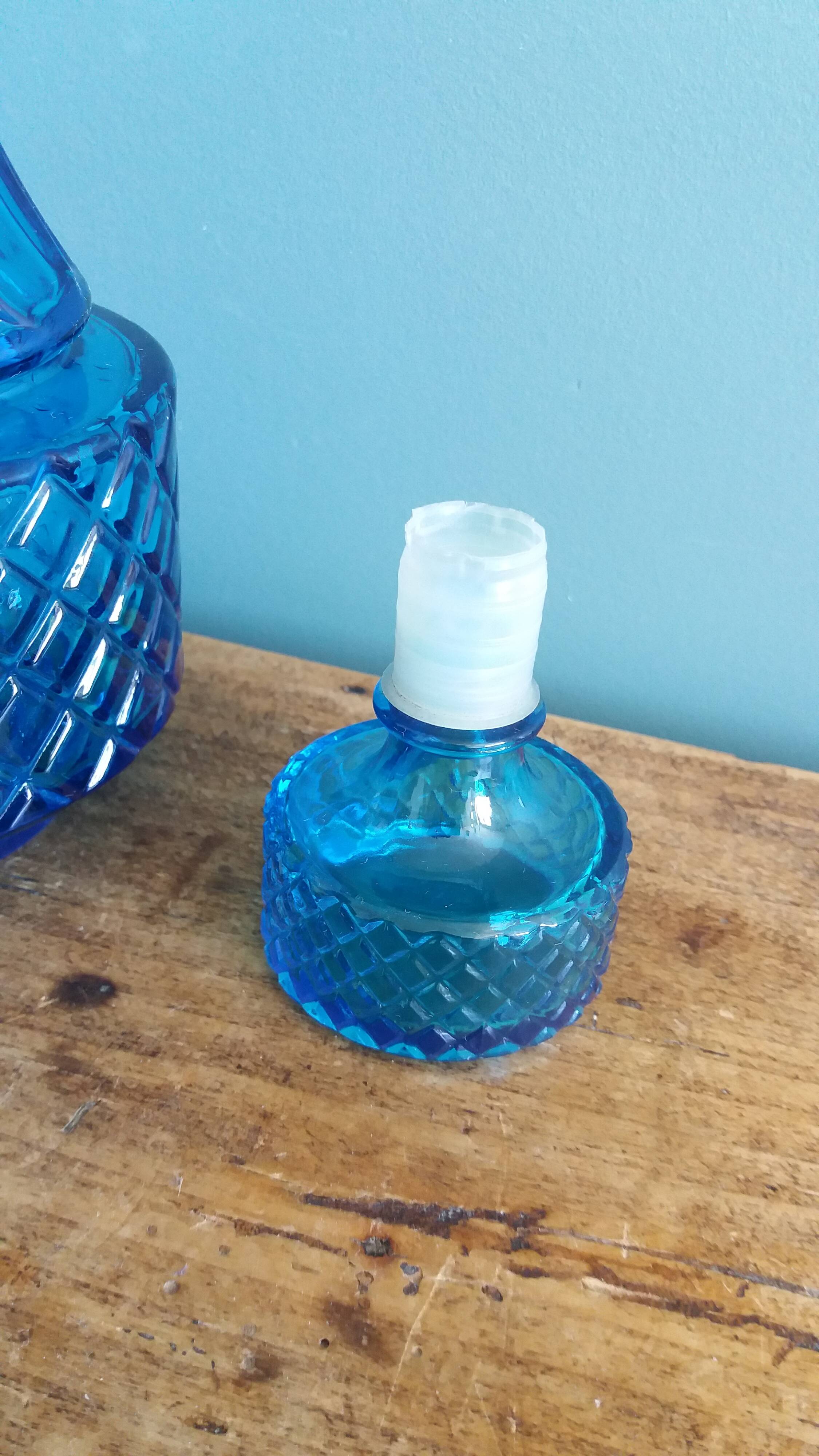 Turquoise glass carafe bottle with a stopper.