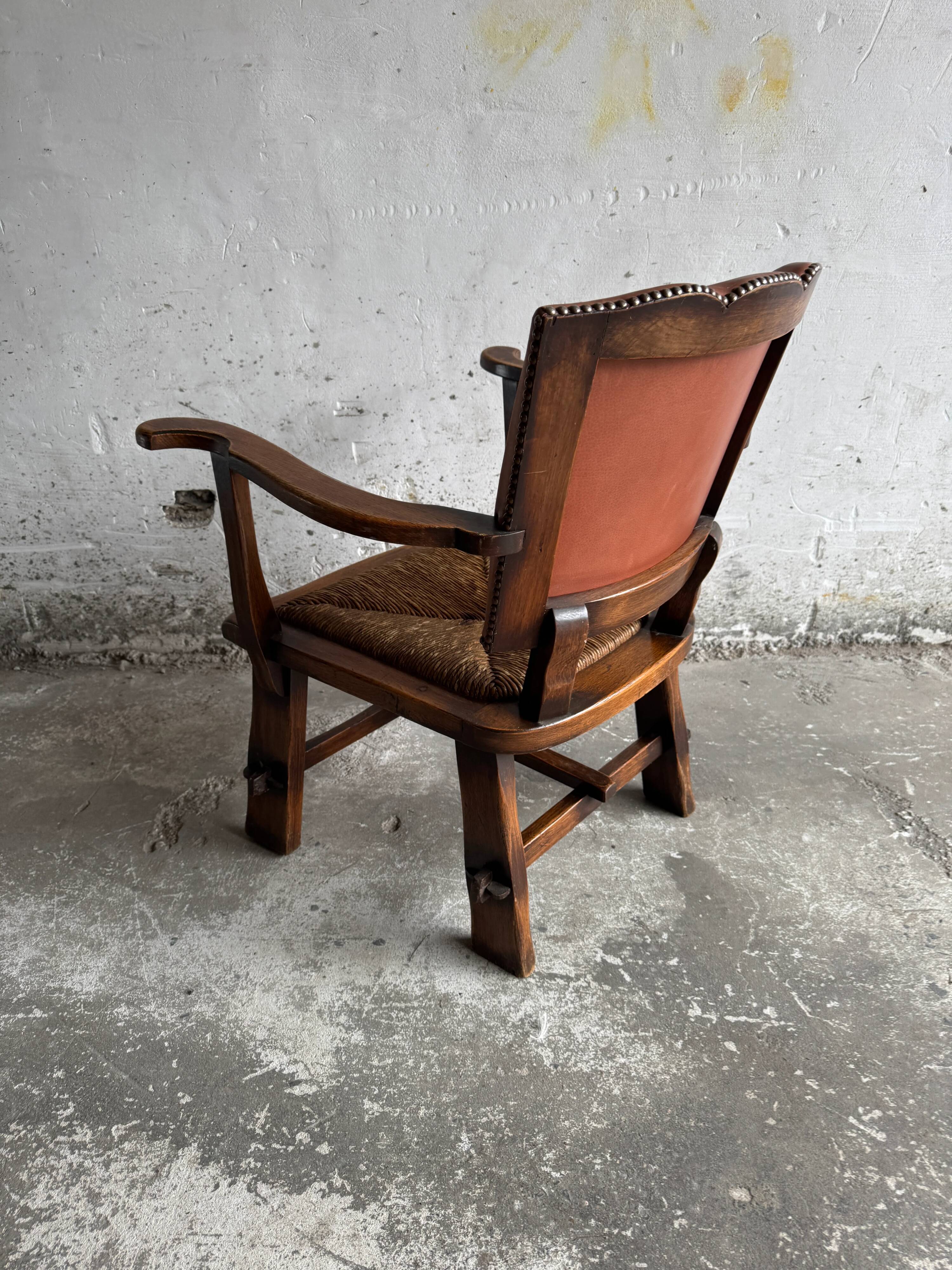 Brutalist dark brown solid wood armchair with natural rattan seat and cognac leather back