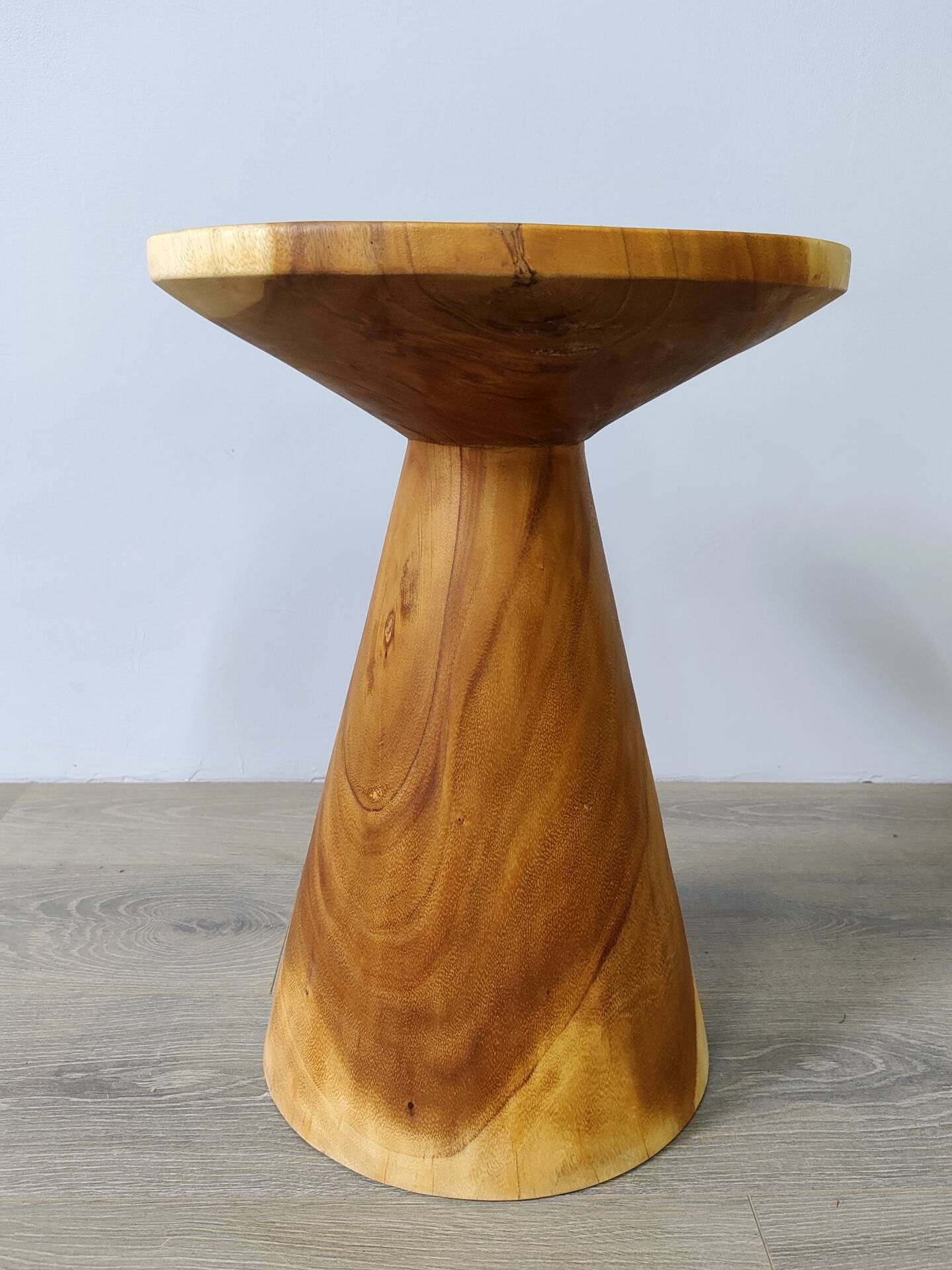 Minimalist side table in solid suar wood with conical legs.