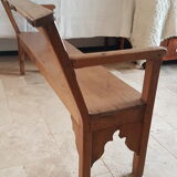 Church bench in fir tree with armrests