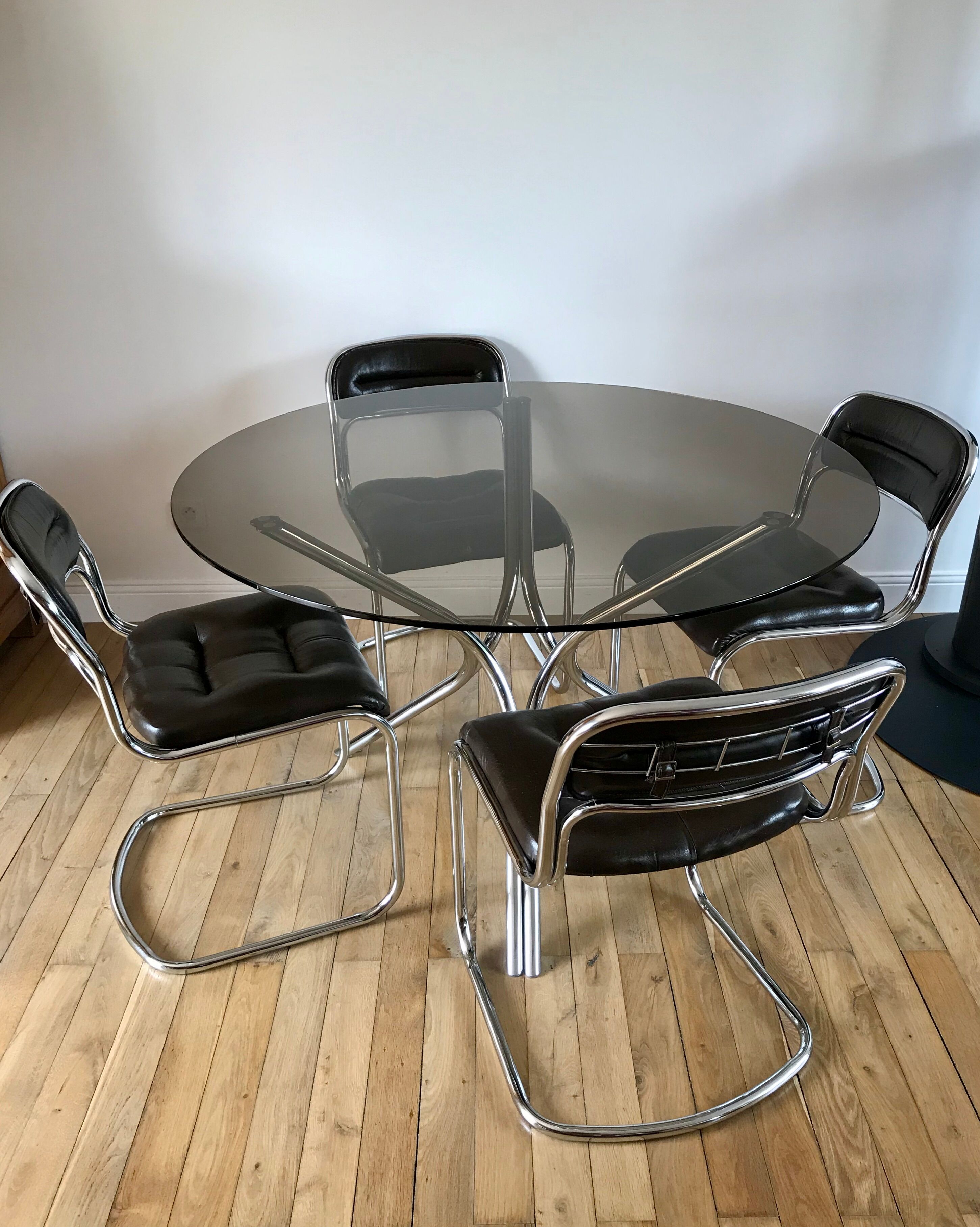 Set consisting of a table in chrome and smoked glass and its 4 tubular chairs in chrome and skaï a