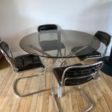 ensemble composé d'une table en chrome et verre fumé et ses 4 chaises tubulaires en chrome et skaï a