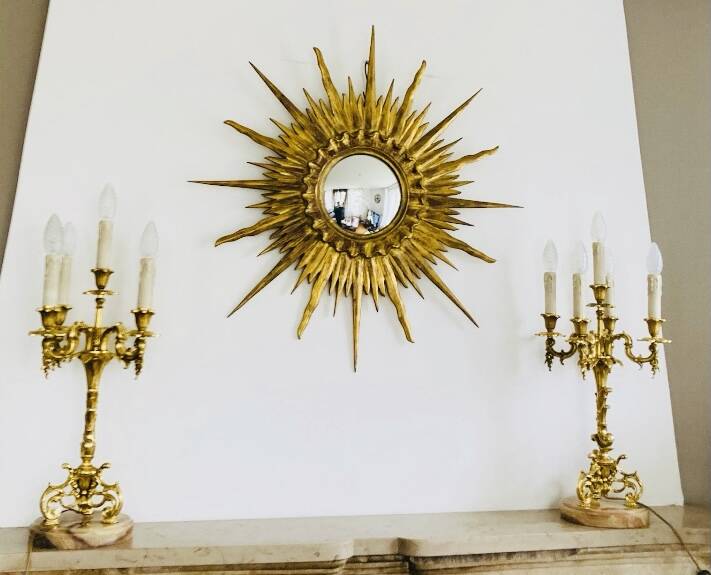 Massive gilded bronze chandeliers from the mid-20th century with marble bases.