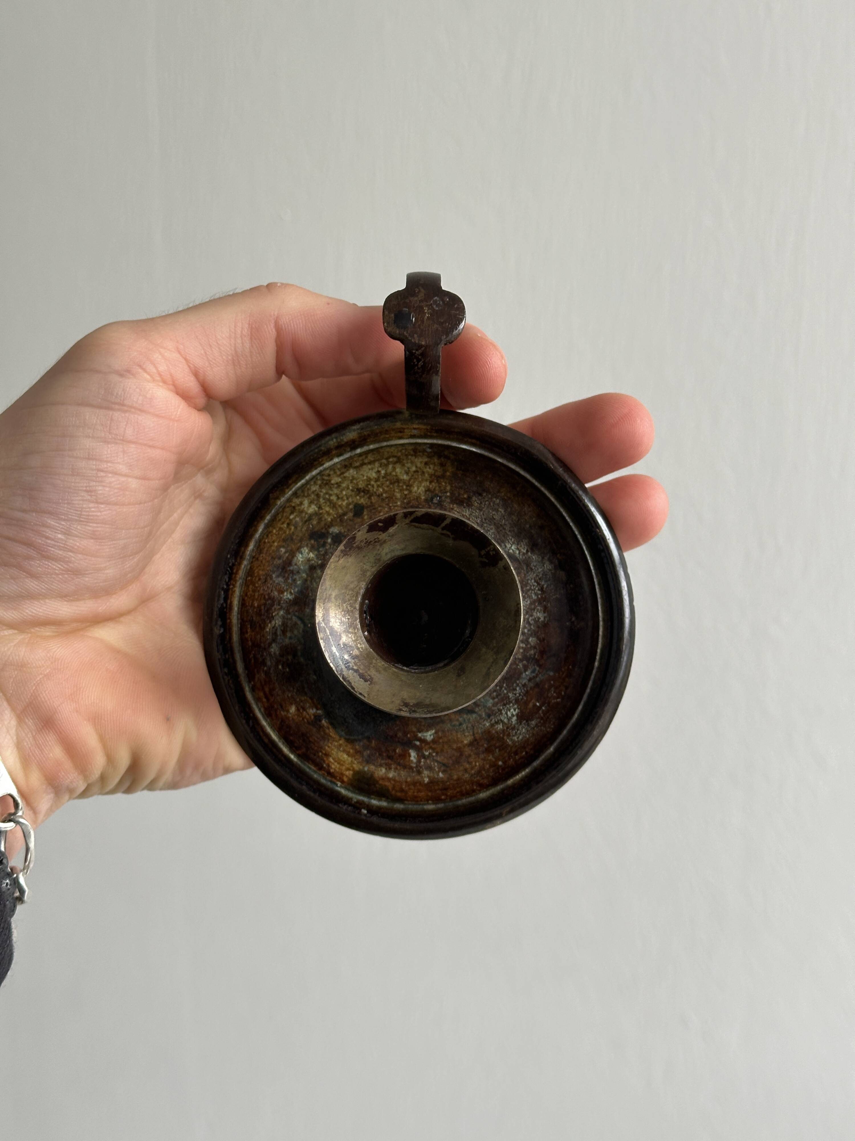 Small antique candle holder in patinated metal