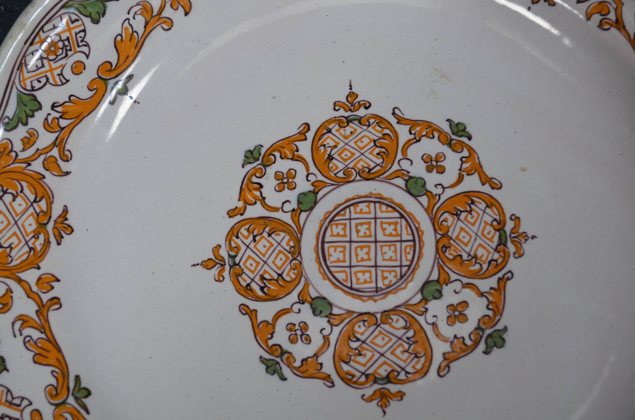 Two 18th century earthenware plates with grand feu decoration in ochre, green and manganese