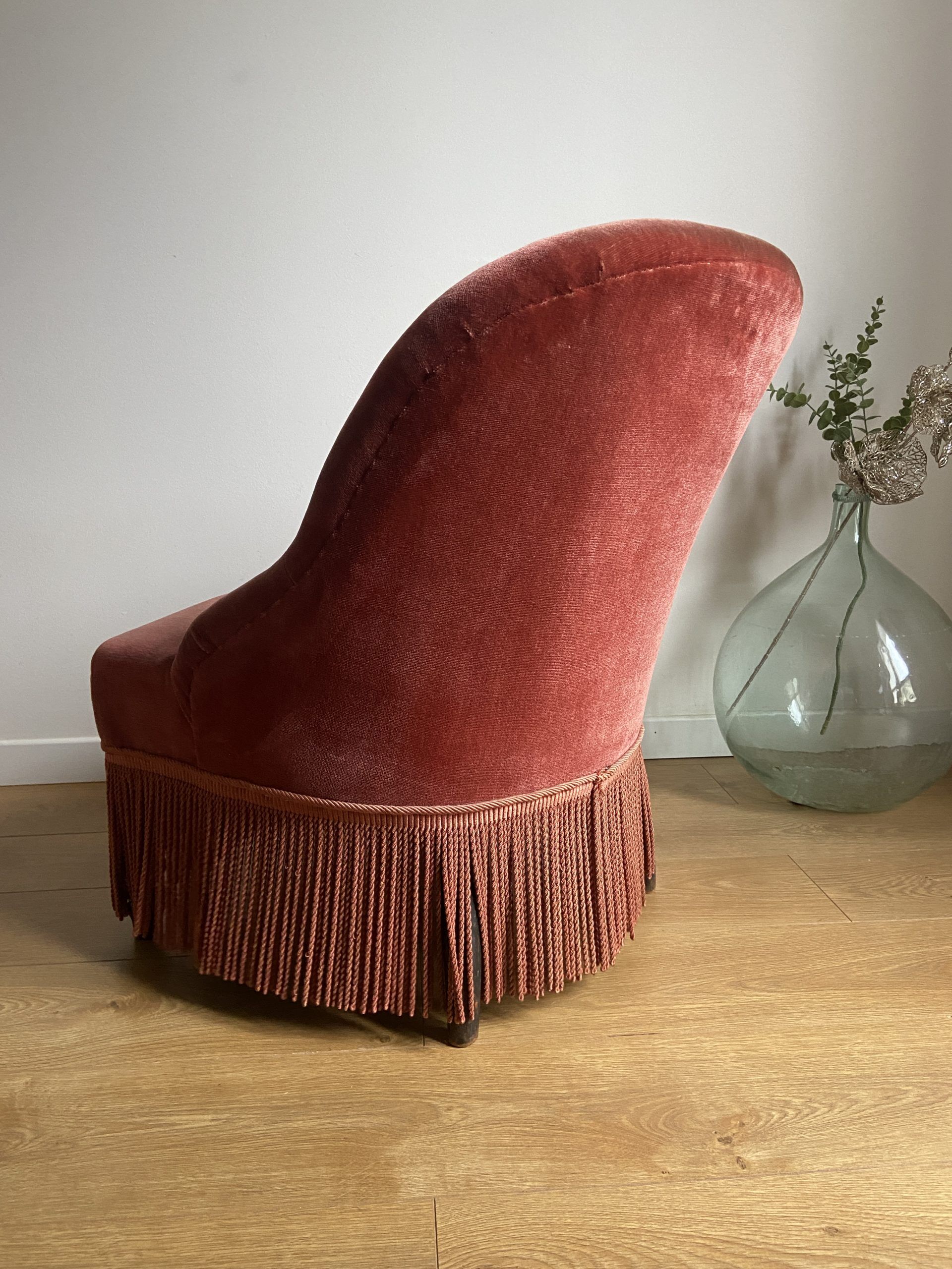 Fauteuil crapaud vintage rose framboise en velours à franges