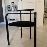 Table de salle à manger noire, en bois, rectangle avec chaises rembourrées.