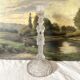 Tall molded glass candle holder with ram heads