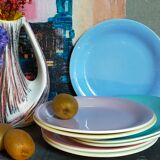 Seven pastel-colored plates mixed with vintage earthenware
