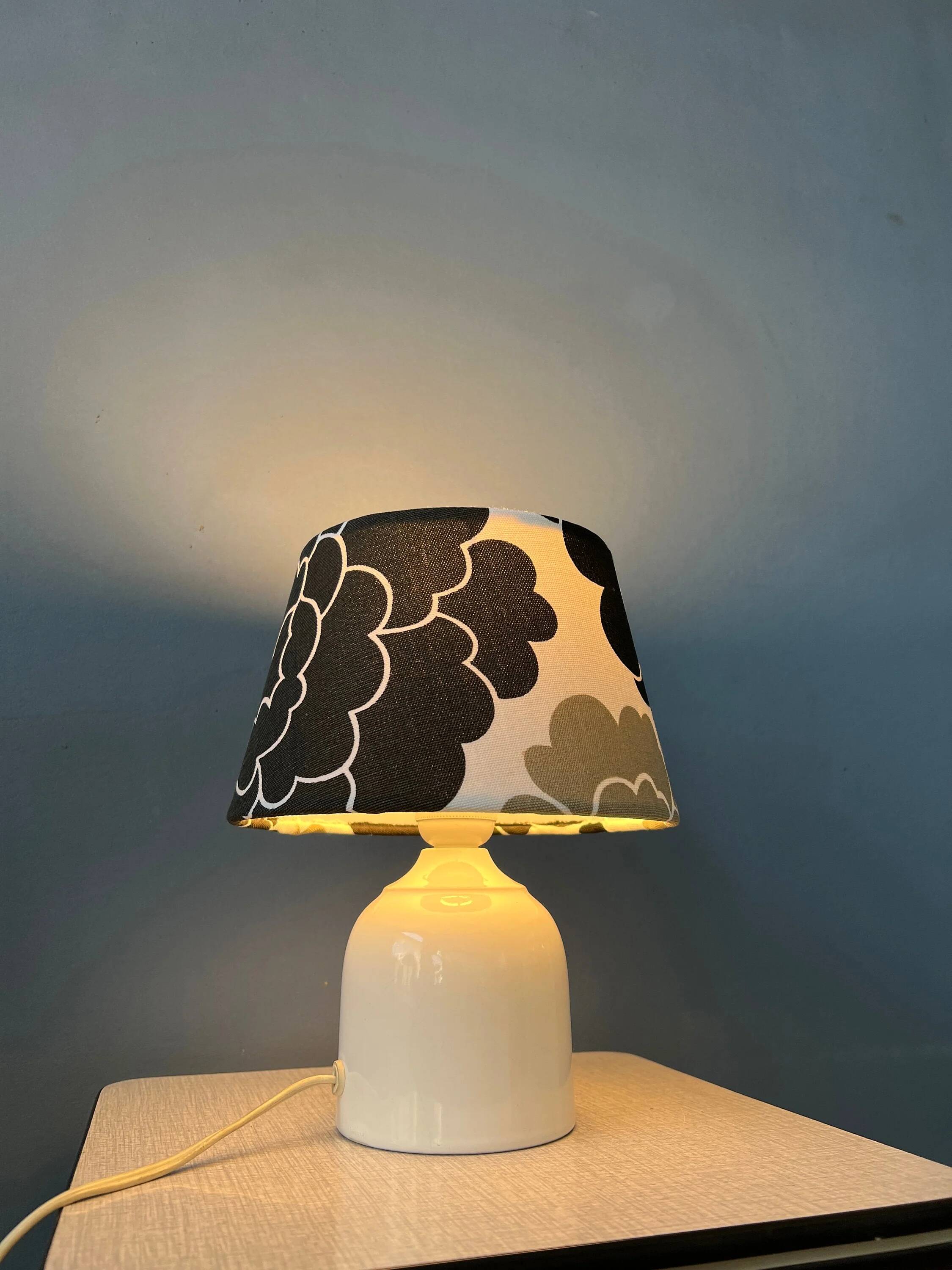 Small Space Age table lamp with a porcelain base and black and white flower shade.
