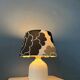 Small Space Age table lamp with a porcelain base and black and white flower shade.