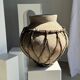Very large light grey terracotta pot with handles and rattan crossbars.