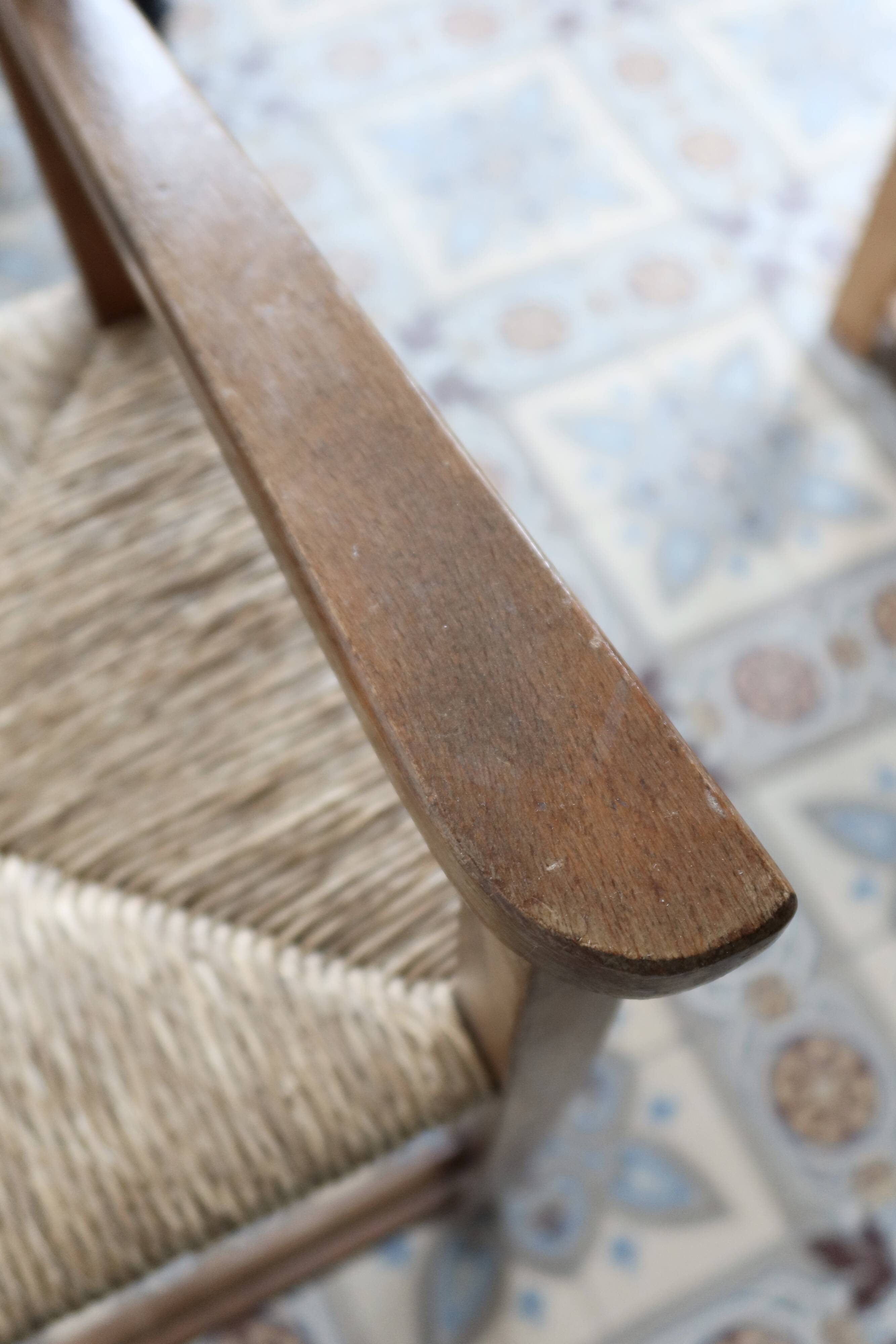 Vintage wooden high chair for children with a straw seat.