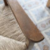 Vintage wooden high chair for children with a straw seat.