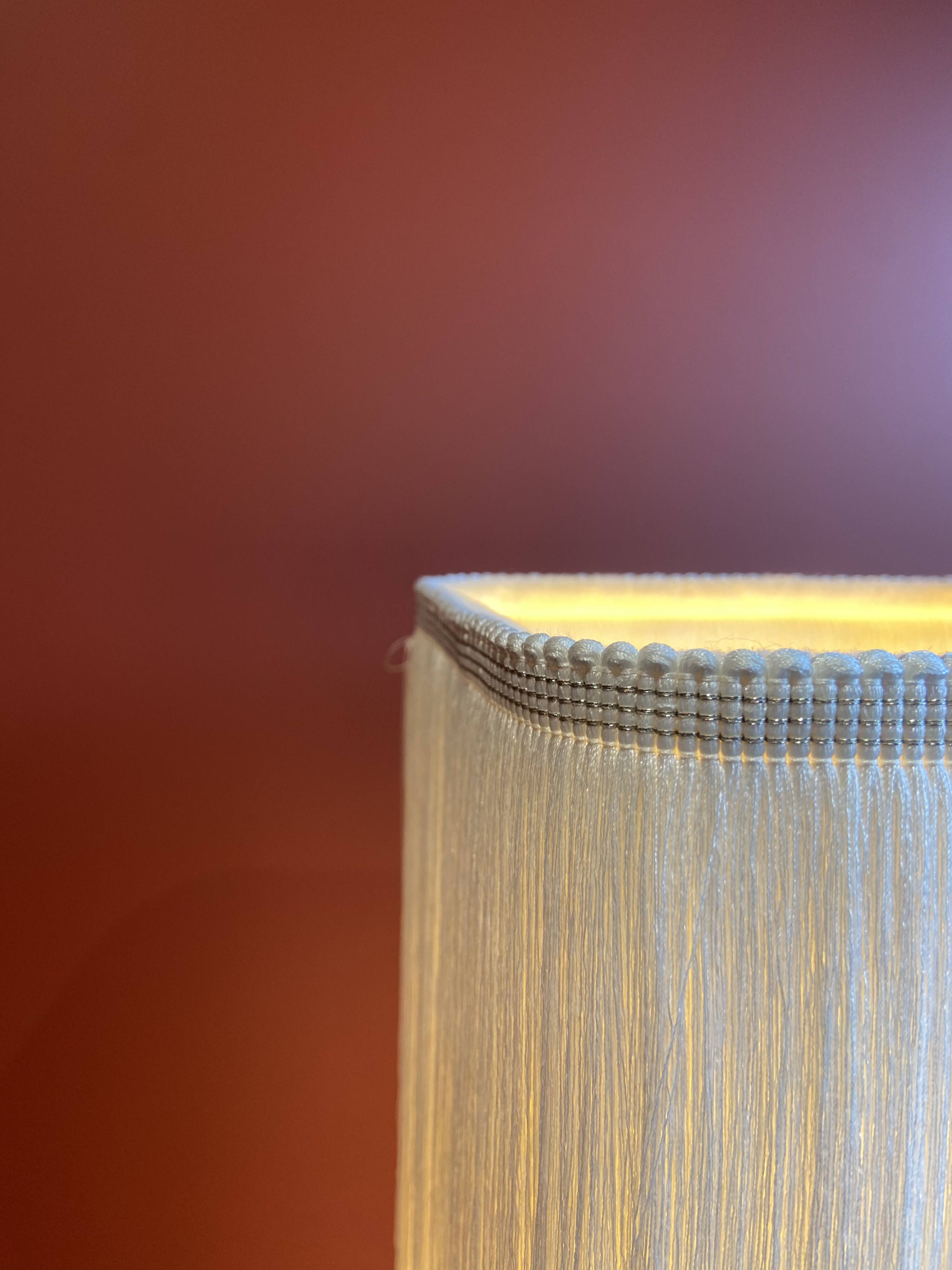 Beige marble stucco base, Houles white ecru fringed lampshade.