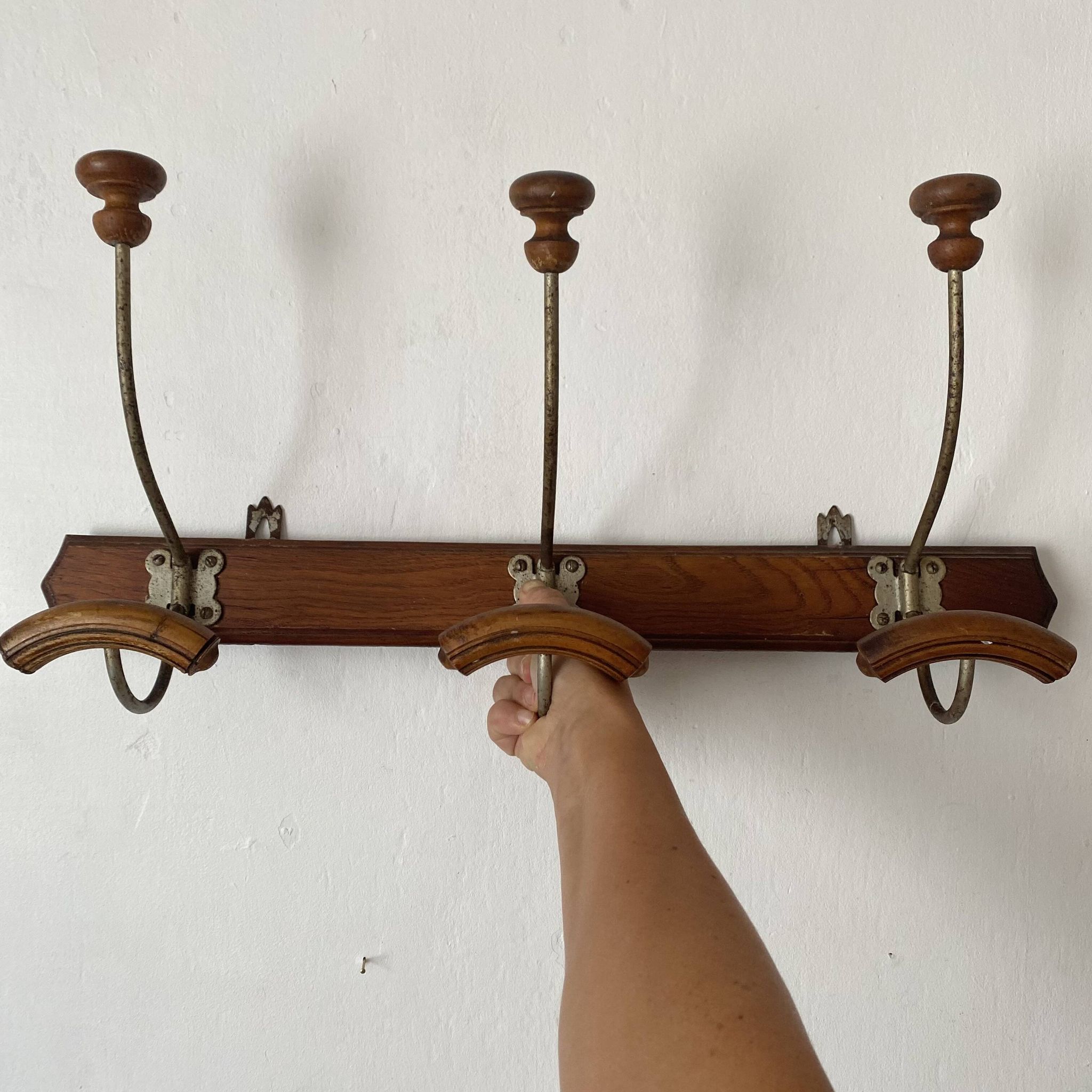 Old wooden and metal wall-mounted coat rack.