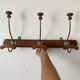Old wooden and metal wall-mounted coat rack.