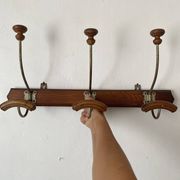Old wooden and metal wall-mounted coat rack.