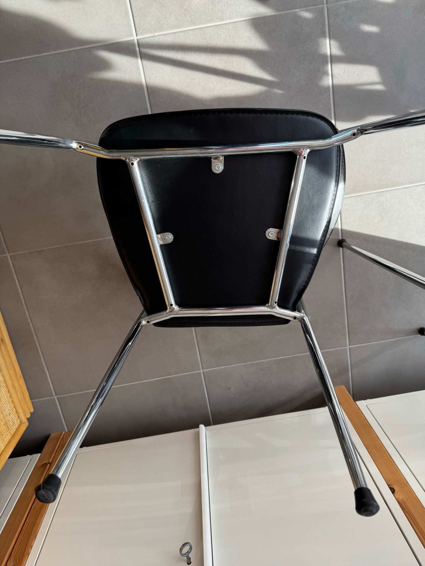 Set of two metal chairs with a brushed finish and black leather.