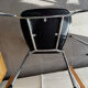 Set of two metal chairs with a brushed finish and black leather.