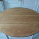 Walnut table with raised flaps, base on verdigris casters.