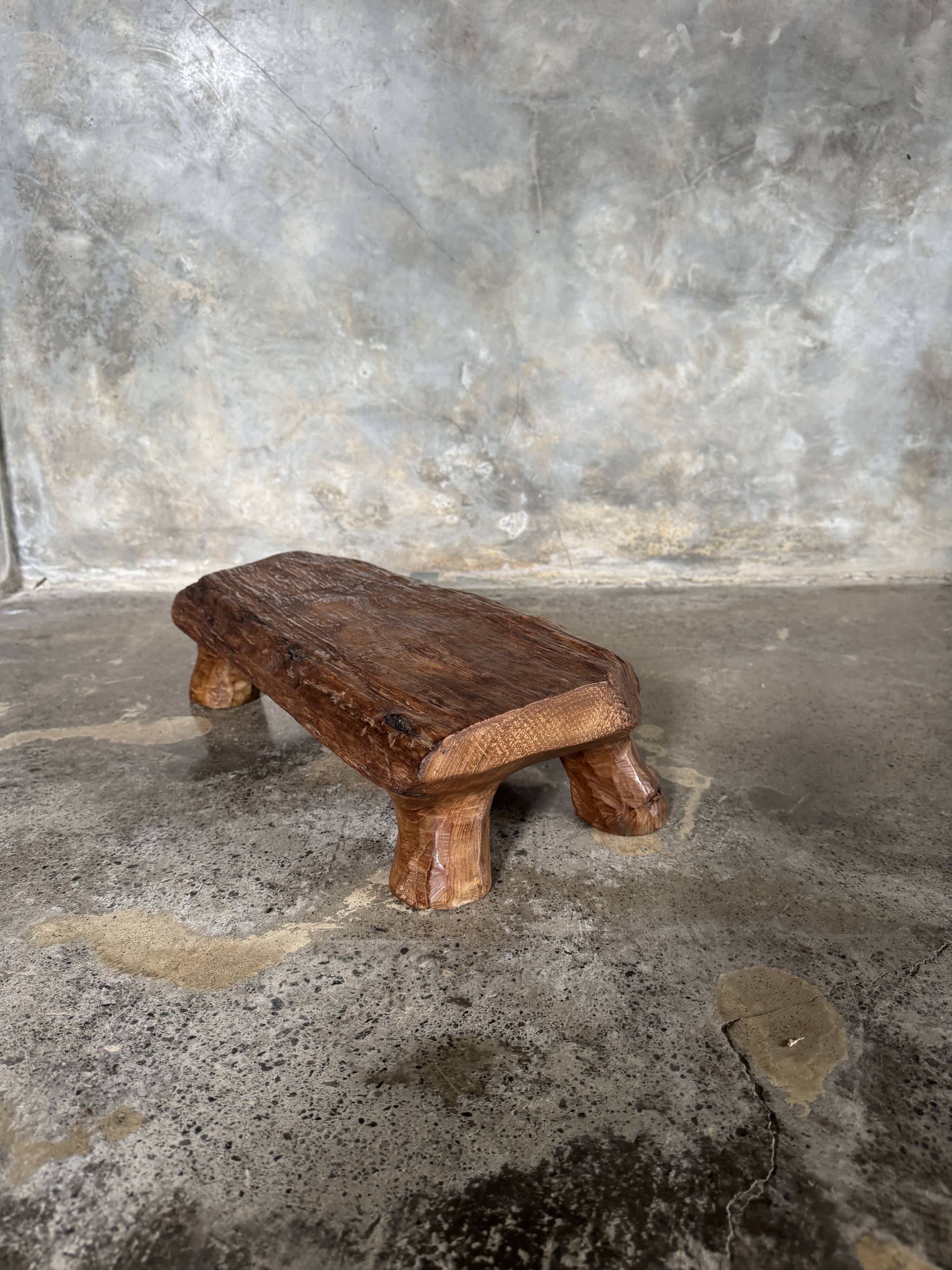 Small stool, footrest in blond teak, organic monoxyle with cut corners.