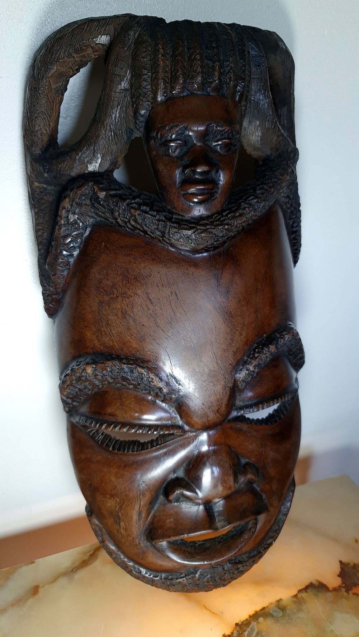 Visage énigmatique d'Afrique sculpté en bois d'ébène