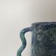Blue-green ceramic vase with abstract wavy handles