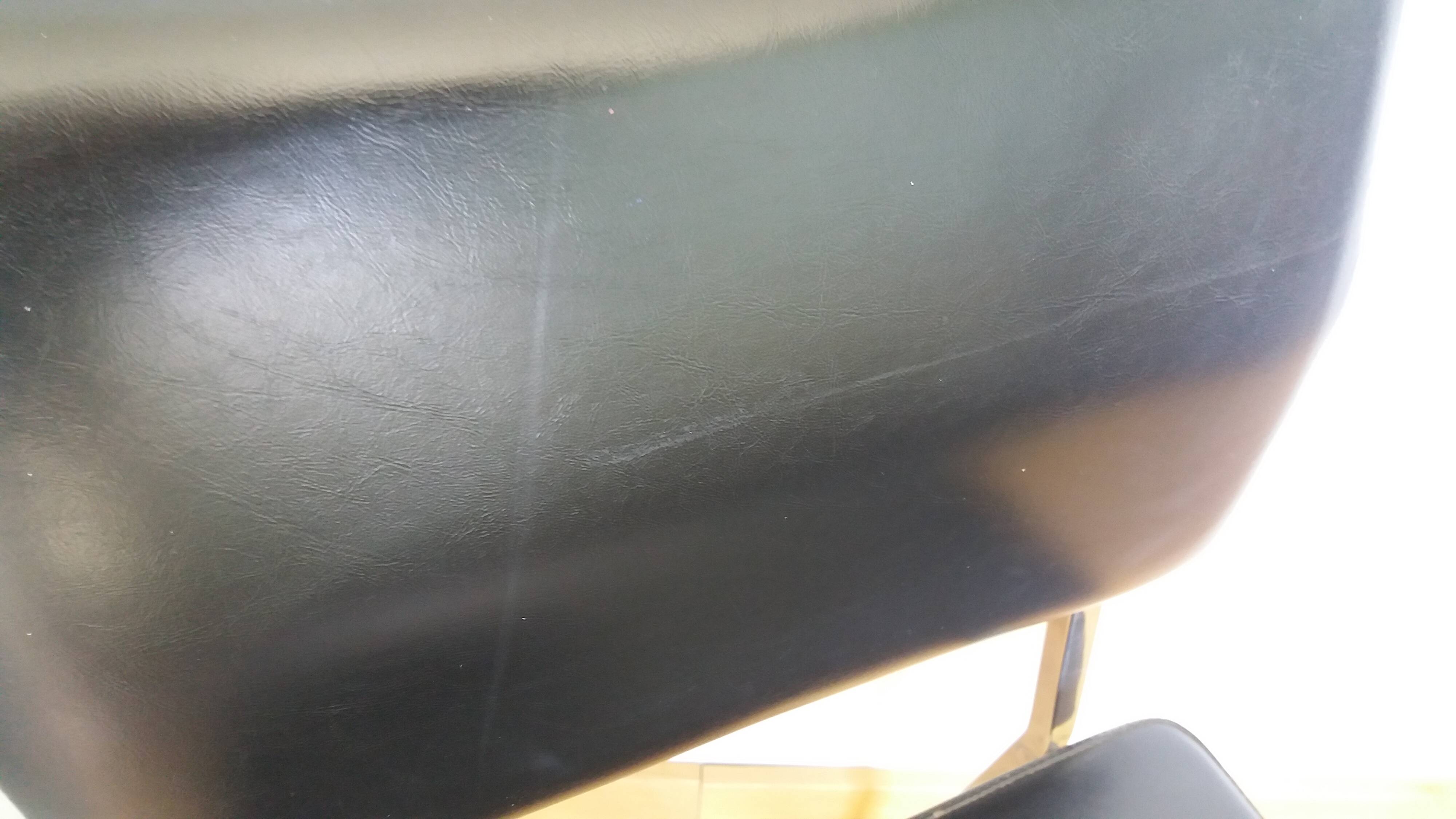 Chrome metal chairs and black faux leather upholstery in retro modernist style.