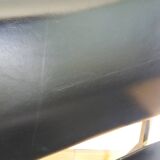 Chrome metal chairs and black faux leather upholstery in retro modernist style.