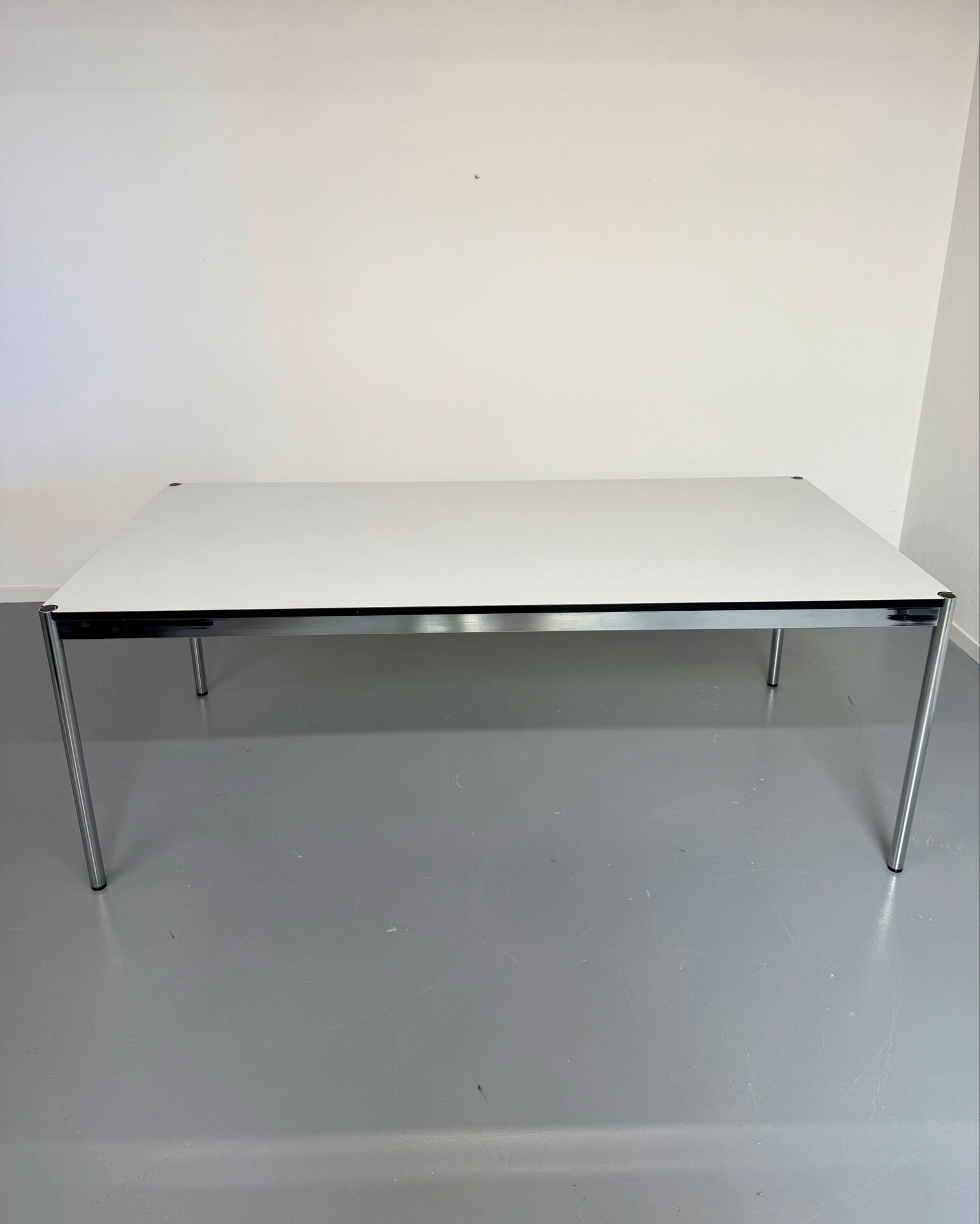 Large table design USM Haller with a white top and chrome structure.