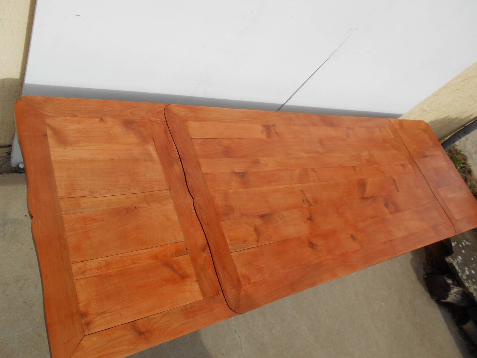 Large solid wood table with integrated extensions.