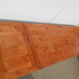 Large solid wood table with integrated extensions.