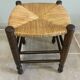 Wooden stool with a straw seat
