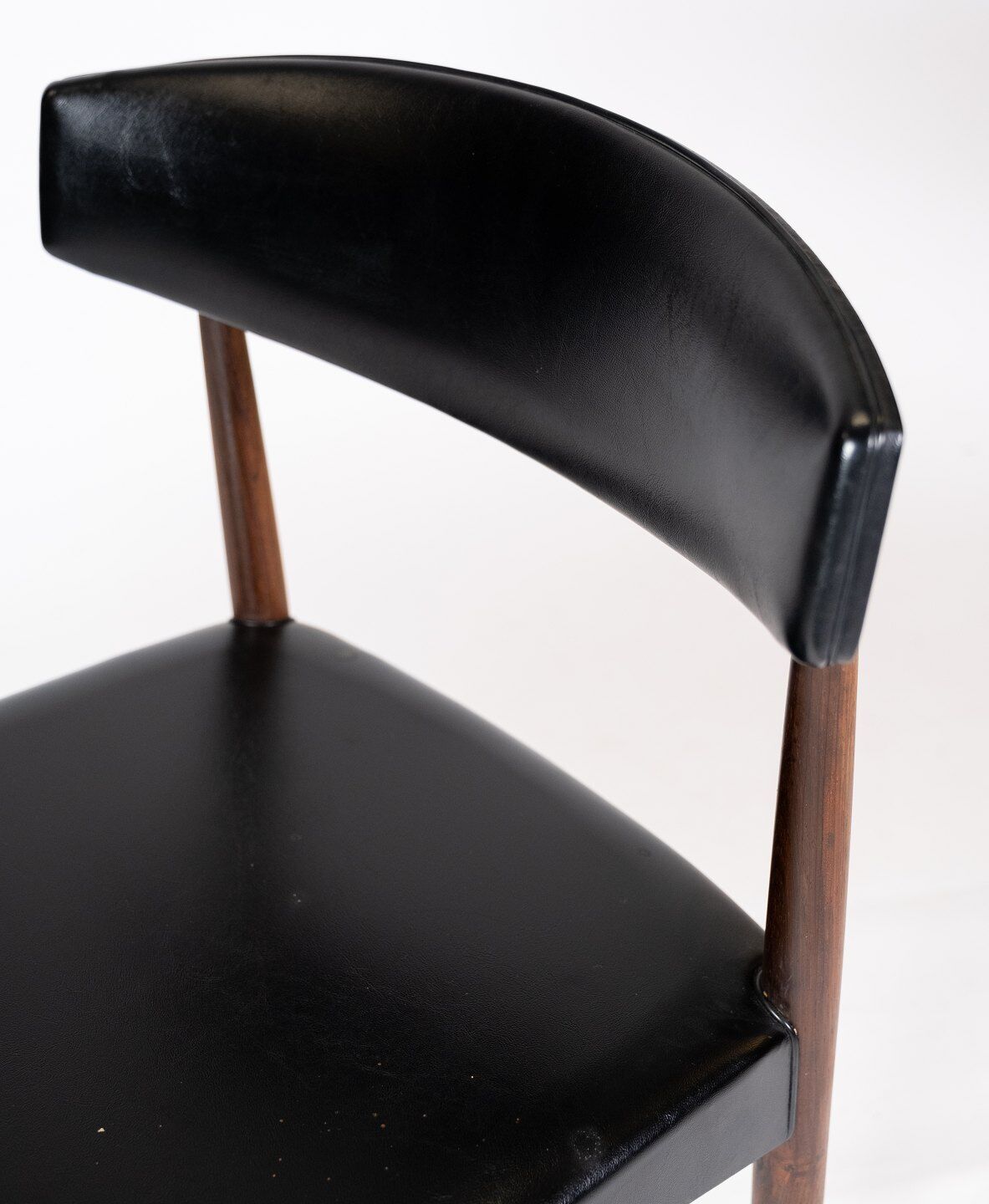 Set of four dining room chairs in rosewood and black leather of danish design from the 1960s.